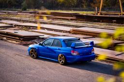 JR Wheels JR32 Guld aluminiumfälg monterade på bil i stämnigsfull miljö