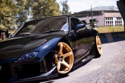 JR Wheels JR32 Gold alloy wheel mounted on car in an atmospheric setting