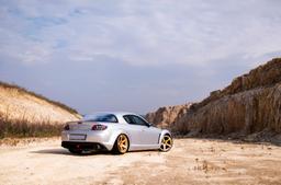 JR Wheels JR32 Gold alloy wheel mounted on car in an atmospheric setting