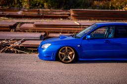 JR Wheels JR32 Gold alloy wheel mounted on car in an atmospheric setting