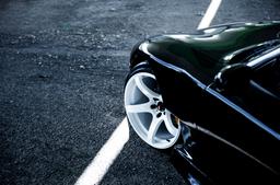 JR Wheels JR32 White alloy wheel mounted on car in an atmospheric setting