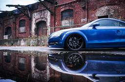 JR Wheels JR33 Black alloy wheel mounted on car in an atmospheric setting