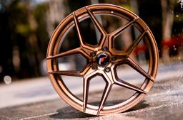 JR Wheels JR34 Bronze alloy wheel mounted on car in an atmospheric setting
