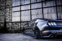 JR Wheels JR34 Black alloy wheel mounted on car in an atmospheric setting