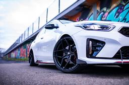 JR Wheels JR34 Black alloy wheel mounted on car in an atmospheric setting