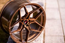 JR Wheels JR34 Bronse aluminiumsfelger montert på bil i en stemningsfull omgivelse