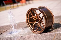 JR Wheels JR34 Bronze alloy wheel mounted on car in an atmospheric setting