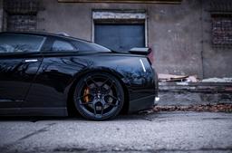 JR Wheels JR34 Black alloy wheel mounted on car in an atmospheric setting