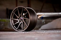 JR Wheels JR36 Bronse aluminiumsfelger montert på bil i en stemningsfull omgivelse