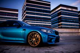 JR Wheels JR37 Brons aluminiumfälg monterade på bil i stämnigsfull miljö