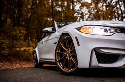 JR Wheels JR37 Bronze alloy wheel mounted on car in an atmospheric setting