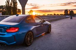 JR Wheels JR37 Bronze alloy wheel mounted on car in an atmospheric setting
