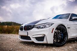 JR Wheels JR37 Black alloy wheel mounted on car in an atmospheric setting