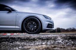 JR Wheels JR38 Black alloy wheel mounted on car in an atmospheric setting