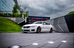 JR Wheels JR38 Bronse aluminiumsfelger montert på bil i en stemningsfull omgivelse