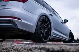 JR Wheels JR38 Black alloy wheel mounted on car in an atmospheric setting