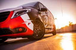 JR Wheels JR38 Black alloy wheel mounted on car in an atmospheric setting