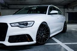 JR Wheels JR38 Black alloy wheel mounted on car in an atmospheric setting