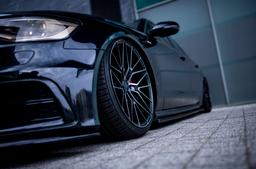 JR Wheels JR38 Black alloy wheel mounted on car in an atmospheric setting