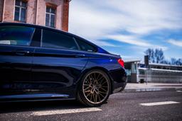 JR Wheels JR38 Bronse aluminiumsfelger montert på bil i en stemningsfull omgivelse