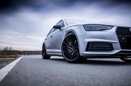 JR Wheels JR38 Black alloy wheel mounted on car in an atmospheric setting