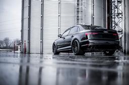 JR Wheels JR38 Black alloy wheel mounted on car in an atmospheric setting