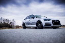 JR Wheels JR38 Black alloy wheel mounted on car in an atmospheric setting