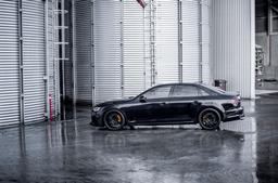 JR Wheels JR38 Black alloy wheel mounted on car in an atmospheric setting