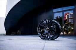 JR Wheels JR42 Black alloy wheel mounted on car in an atmospheric setting