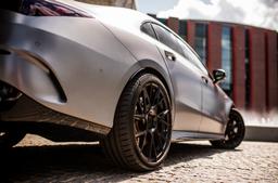 JR Wheels JR42 Black alloy wheel mounted on car in an atmospheric setting