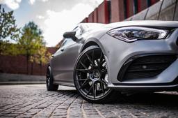 JR Wheels JR42 Black alloy wheel mounted on car in an atmospheric setting