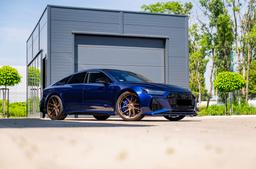 JR Wheels JR44 Bronze alloy wheel mounted on car in an atmospheric setting
