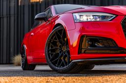 JR Wheels JR44 Svart aluminiumfälg monterade på bil i stämnigsfull miljö