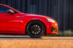 JR Wheels JR44 Svart aluminiumfälg monterade på bil i stämnigsfull miljö