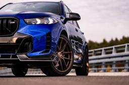 JR Wheels JR44 Bronze alloy wheel mounted on car in an atmospheric setting