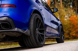 JR Wheels JR44 Black alloy wheel mounted on car in an atmospheric setting