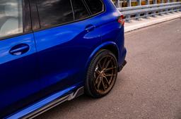 JR Wheels JR44 Brons aluminiumfälg monterade på bil i stämnigsfull miljö