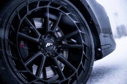 JR Wheels JR45 Black alloy wheel mounted on car in an atmospheric setting