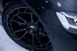 JR Wheels JR45 Black alloy wheel mounted on car in an atmospheric setting