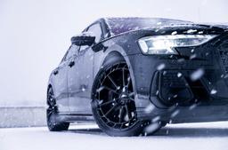 JR Wheels JR45 Black alloy wheel mounted on car in an atmospheric setting