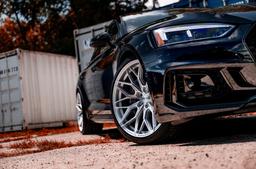 JR Wheels JR46 Silver alloy wheel mounted on car in an atmospheric setting