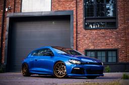 JR Wheels JR5 Bronze alloy wheel mounted on car in an atmospheric setting