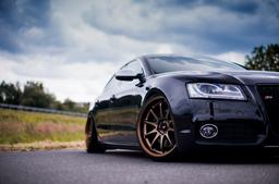 JR Wheels JR5 Bronze alloy wheel mounted on car in an atmospheric setting