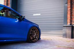 JR Wheels JR5 Bronze alloy wheel mounted on car in an atmospheric setting