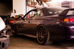 JR Wheels JR5 Bronze alloy wheel mounted on car in an atmospheric setting