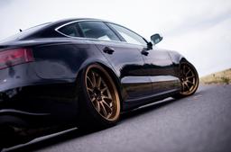 JR Wheels JR5 Bronze alloy wheel mounted on car in an atmospheric setting