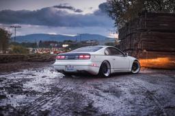 JR Wheels JR6 Black alloy wheel mounted on car in an atmospheric setting