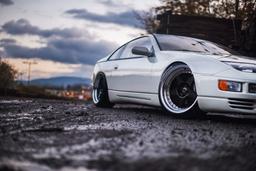 JR Wheels JR6 Black alloy wheel mounted on car in an atmospheric setting
