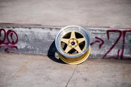 JR Wheels JR6 Gold alloy wheel mounted on car in an atmospheric setting