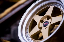 JR Wheels JR6 Gold alloy wheel mounted on car in an atmospheric setting